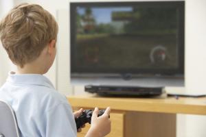 Boy playing computer game on TV