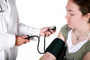 Female doctor monitoring blood pressure
